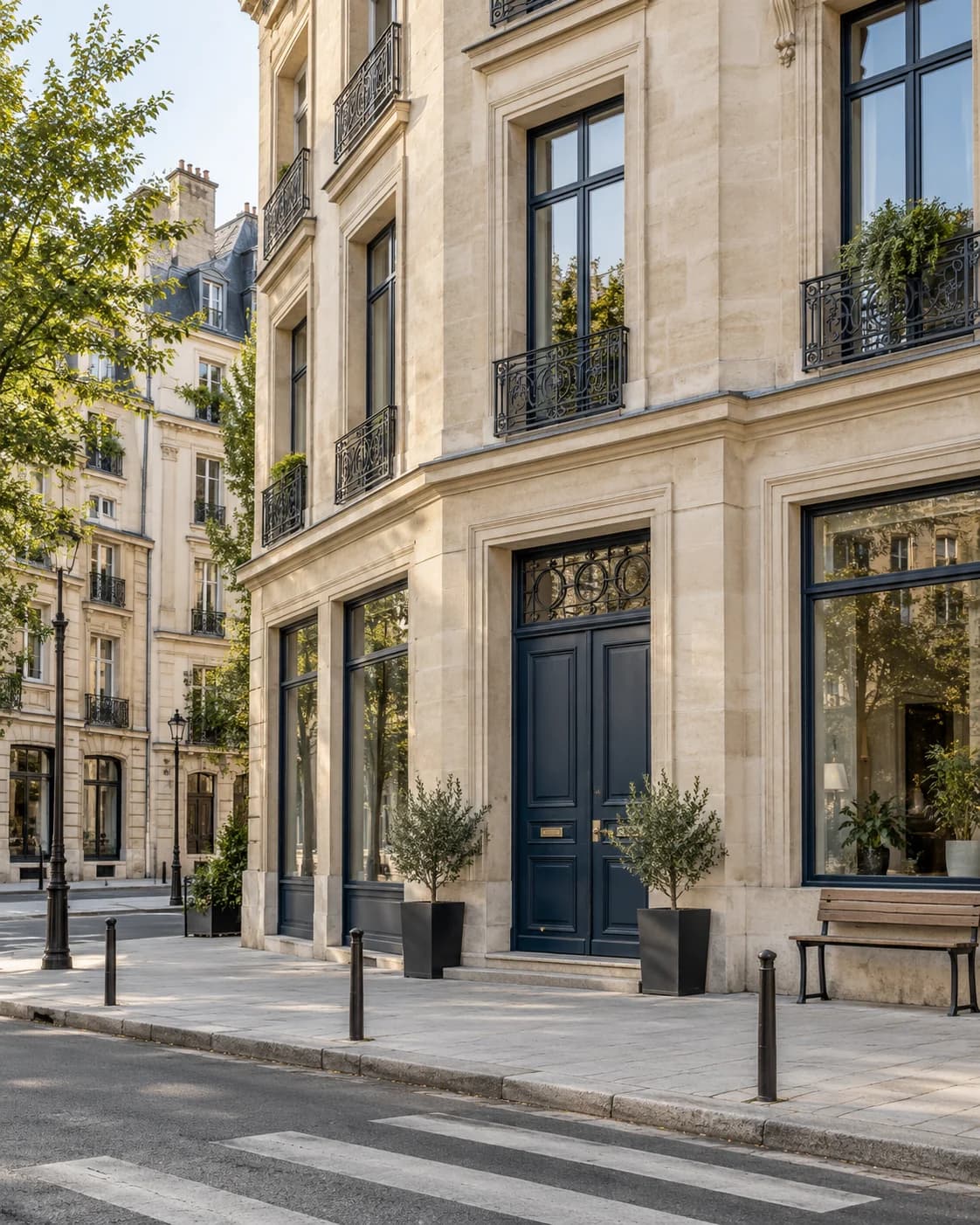 Warm stone residential buildings and ground-floor shopfronts along a quiet neighbourhood street