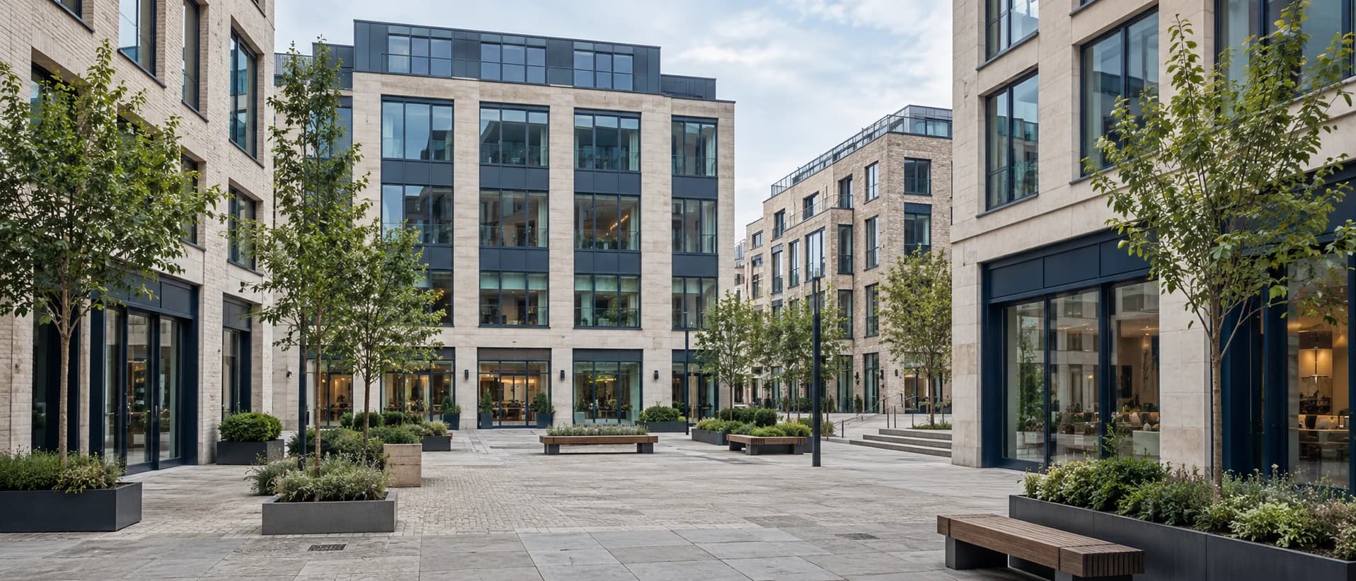 Contemporary office buildings and ground-floor retail around a quiet commercial courtyard